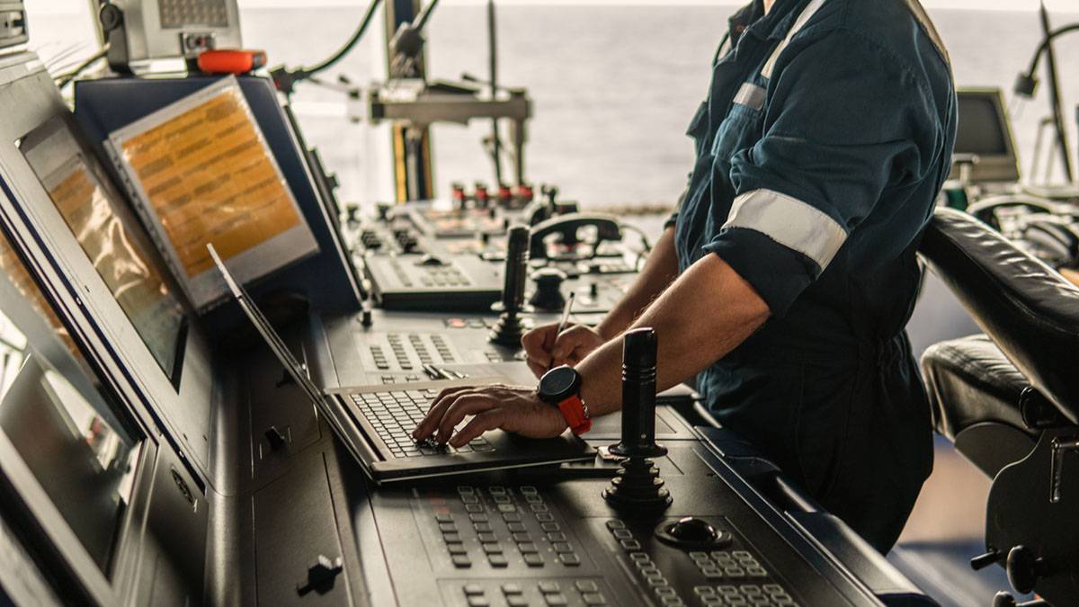 marine navigational officer using laptop at sea on the bridge